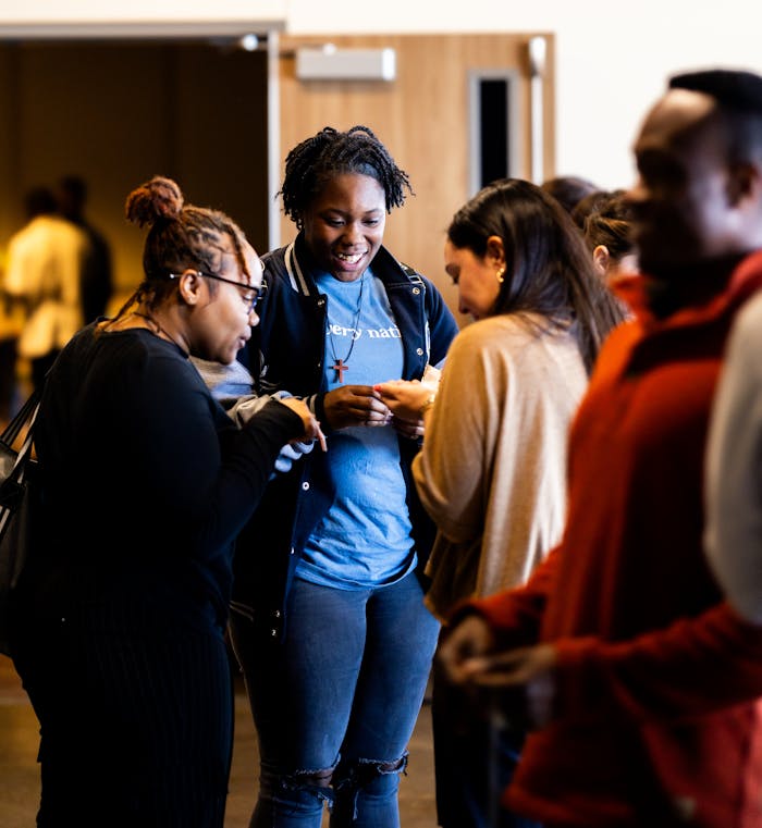 A diverse group of young adults sharing a lively and joyful moment indoors.